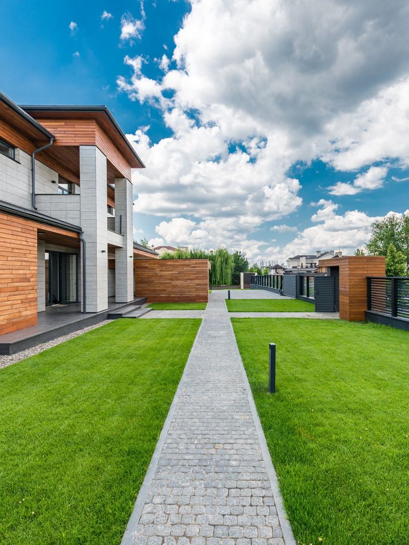 Casas modernas com gramado e caminho de pedra entre elas