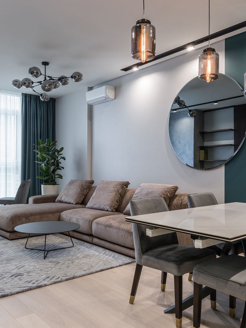 Sala de estar mobiliada com sofá, mesa de jantar e luminárias